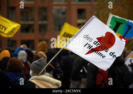 Un manifestant détient un drapeau de la Ligue des droits de l'homme pendant la manifestation. Des milliers de manifestants ont manifesté à nouveau contre le projet de loi sur la sécurité mondiale promu par le président français Macron et sa majorité et pour obtenir davantage de moyens pour le système de santé publique et les hôpitaux. Le projet de loi sur la sécurité mondiale interdit à quiconque de photographier ou de filmer des membres de la police s'il n'est pas bafoué : les transgresseurs pourraient être condamnés jusqu'à un an de prison et une amende de €45,000. Le projet de loi prévoit également de généraliser la reconnaissance faciale dans les espaces pubiens comme en Chine. Le défenseur français des droits, la Commission nationale française des droits de l'homme ( Banque D'Images