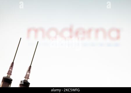 Illustration photo d'une seringue médicale avec aiguille vue devant le logo de la société pharmaceutique Moderna. Moderna s'attend à ce que la décision américaine, une approbation pour une utilisation d'urgence, le candidat vaccin mRNA-1273 sur 17 décembre 2020 de la FDA et l'approbation européenne pour le vaccin COVID-19 en janvier 2021. Moderna est une société américaine de biotechnologie basée à Cambridge, Massachusetts, qui développe des technologies de vaccins basées sur l'ARNm de l'ARN messager. La pandémie du coronavirus, l'une des plus grandes crises sanitaires au monde, entraînera le plus grand programme de vaccination de l'histoire humaine. Poste Banque D'Images