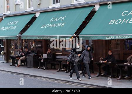 Les gens sont vus assis devant un pub à Soho avant l'introduction de restrictions plus sévères de coronavirus à l'approche de Noël, le 15 décembre 2020 à Londres, en Angleterre. A partir de demain, le Grand Londres, ainsi que certaines parties de l'Essex et du Hertfordshire, seront soumises aux restrictions du niveau 3 du coronavirus, ce qui entraînera la fermeture des pubs, bars, restaurants, hôtels et lieux de divertissement intérieurs tels que les théâtres et les cinémas, car les taux d'infection sont bien au-dessus de la moyenne nationale et continuent d'augmenter. (Photo de Wiktor Szymanowicz/NurPhoto) Banque D'Images