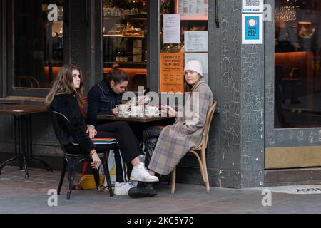 Les gens sont vus assis devant un café-bar à Soho avant l'introduction de restrictions plus sévères de coronavirus à l'approche de Noël, le 15 décembre 2020 à Londres, en Angleterre. A partir de demain, le Grand Londres, ainsi que certaines parties de l'Essex et du Hertfordshire, seront soumises aux restrictions du niveau 3 du coronavirus, ce qui entraînera la fermeture des pubs, bars, restaurants, hôtels et lieux de divertissement intérieurs tels que les théâtres et les cinémas, car les taux d'infection sont bien au-dessus de la moyenne nationale et continuent d'augmenter. (Photo de Wiktor Szymanowicz/NurPhoto) Banque D'Images