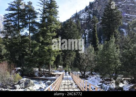 Le peuple cachemiri traverse un pont à pied sur un ruisseau partiellement gelé pendant la saison d'hiver dans le district de Ganderbal, dans le Cachemire administré par l'Inde, le 20 décembre 2020. (Photo de Muzamil Mattoo/NurPhoto) Banque D'Images