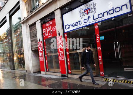 Un homme passe devant un magasin de souvenirs touristiques fermé sur Oxford Street à Londres, en Angleterre, sur 21 décembre 2020. Londres a passé sa deuxième journée de ce qui pourrait être des mois sous les nouvelles restrictions de 'Tier 4' du coronavirus aujourd'hui. En vertu des règles de niveau 4, les magasins non essentiels et de nombreuses autres entreprises, y compris les salles de sport et les coiffeurs, doivent fermer, les personnes ayant reçu l'instruction de rester à la maison autre que pour des circonstances exemptées, y compris les voyages au travail ou à l'éducation. Le mélange à l'intérieur entre ceux des différents ménages est également interdit sous le nouveau niveau, ce qui a bouleverser les plans de Noël pour une immense part de la population Banque D'Images