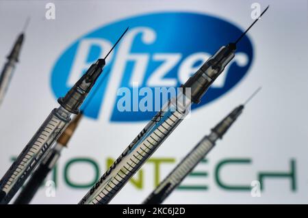 Une illustration des seringues médicales vues devant le logo Pfizer-BionTech s'affiche à l'écran. Lundi, 28 décembre 2020, à Dublin, Irlande. (Photo par Artur Widak/NurPhoto) Banque D'Images