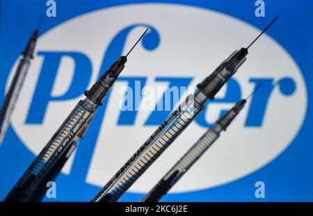 Une image d'illustration des seringues médicales vues devant le logo de Pfizer affichée à l'écran. Lundi, 28 décembre 2020, à Dublin, Irlande. (Photo par Artur Widak/NurPhoto) Banque D'Images