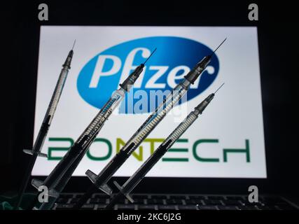 Une illustration des seringues médicales vues devant le logo Pfizer-BionTech s'affiche à l'écran. Lundi, 28 décembre 2020, à Dublin, Irlande. (Photo par Artur Widak/NurPhoto) Banque D'Images