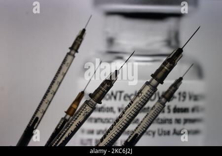 Une image d'illustration de seringues médicales vue devant une image d'un flacon contenant le vaccin Pfizer-BionTech affichée à l'écran. Lundi, 28 décembre 2020, à Dublin, Irlande. (Photo par Artur Widak/NurPhoto) Banque D'Images