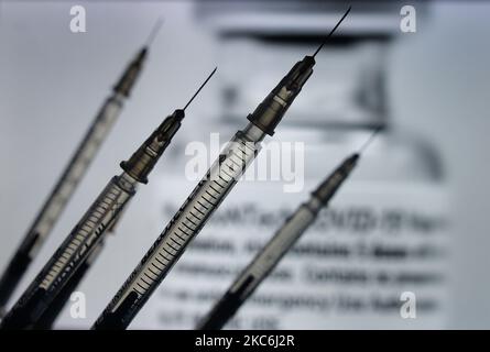 Une image d'illustration de seringues médicales vue devant une image d'un flacon contenant le vaccin Pfizer-BionTech affichée à l'écran. Lundi, 28 décembre 2020, à Dublin, Irlande. (Photo par Artur Widak/NurPhoto) Banque D'Images