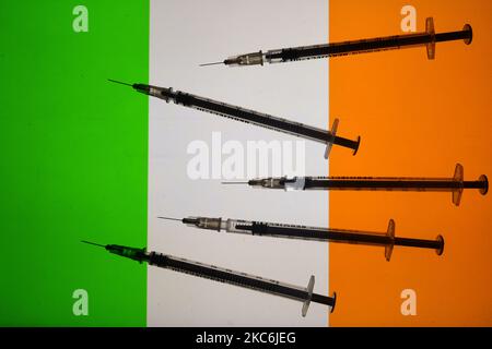 Une illustration des seringues médicales vues devant le drapeau de la République d'Irlande. La vaccination contre la COVID en Irlande commence aujourd'hui, un jour plus tôt que prévu, après avoir augmenté la pression sur les services de santé. Un petit nombre de personnes dans quatre hôpitaux de Dublin recevront leur première vaccination. L'Allemagne, la Hongrie et la Slovaquie ont lancé la campagne de vaccination COVID-19 le samedi 26 décembre, une journée plus tôt que le déploiement coordonné prévu par la Commission européenne dans tous les États membres. Mardi, 29 décembre 2020, à Dublin, Irlande. (Illustration photo par Artur Widak/NurPhoto) Banque D'Images