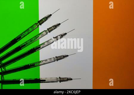 Une illustration des seringues médicales vues devant le drapeau de la République d'Irlande. La vaccination contre la COVID en Irlande commence aujourd'hui, un jour plus tôt que prévu, après avoir augmenté la pression sur les services de santé. Un petit nombre de personnes dans quatre hôpitaux de Dublin recevront leur première vaccination. L'Allemagne, la Hongrie et la Slovaquie ont lancé la campagne de vaccination COVID-19 le samedi 26 décembre, une journée plus tôt que le déploiement coordonné prévu par la Commission européenne dans tous les États membres. Mardi, 29 décembre 2020, à Dublin, Irlande. (Illustration photo par Artur Widak/NurPhoto) Banque D'Images