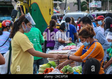 Les acheteurs du marché public d'Antipolo portant des masques et des écrans faciaux comme protection contre la COVID-19, sur 31 décembre 2020 à Antipolo, Philippines. Le gouvernement exige que les gens portent un écran facial obligatoire avec un masque facial pour éviter le risque d'infection de COVID-19. Au 30 décembre 2020, les Philippines ont signalé 472 532 cas et 9 230 décès. (Photo par Ryan Eduard Benaid/NurPhoto) Banque D'Images