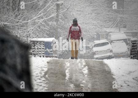 Un homme traversant un pont de pied pendant qu'il neige à Srinagar sur 03 janvier 2021. Le département météorologique indien a prédit une chute de neige modérée à travers le Cachemire et une forte chute de neige dans des régions plus hautes. La route de 270 kilomètres Srinagar-Jammu la seule route reliant le Cachemire à d'autres parties du pays a été fermée après une chute de neige fraîche. Au moins quinze personnes ont été blessées dans différents accidents de la route à travers Jammu-et-Cachemire en raison de routes glissantes, a rapporté une agence de presse locale. (Photo par Faisal Khan/NurPhoto) Banque D'Images