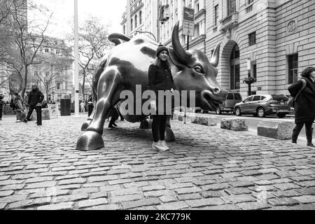 Photo noir et blanc en noir et blanc de la sculpture en bronze de Charging Bull, également connue sous le nom de Wall Street Bull ou Bowling Green Bull à New York avec des touristes autour de prendre des photos de lui comme il est un point de repère, une destination touristique, Une attraction et un symbole populaires pour Wall Street et le quartier financier, ainsi que l'optimisme financier agressif et la prospérité, la richesse et la chance, situé sur Broadway dans le quartier financier de Manhattan. Il a été créé par Arturo Di Modica en 1989. New York, Etats-Unis le 2019 novembre (photo de Nicolas Economou/NurPhoto) Banque D'Images