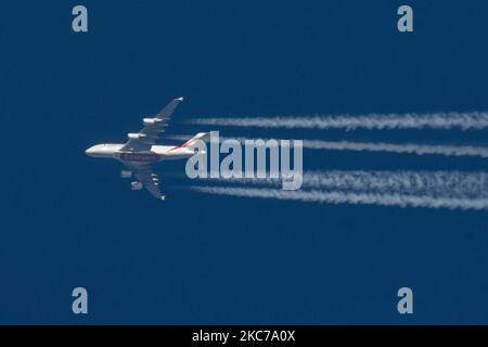 Emirates Airbus A380 comme vu voler dans le ciel bleu au-dessus des pays-Bas en Europe la route de Dubai DXB, eau à Manchester MAN au Royaume-Uni. L'avion long-courrier à double étage à corps large survolant est immatriculé A6-EVL et est alimenté par 4x moteurs à réaction RR Trent 972. Emirates a relancé ses vols avec le A388 après que la flotte ait été mise à terre pour les restrictions de voyage du coronavirus. Le survoler crée contrail ou chemTrail en naviguant à 40,000 pieds, formant une ligne blanche de sentier de condensation dans l'atmosphère qui se trouve derrière. Emirates EK ème porte-drapeau de Dubaï - United Arab Banque D'Images