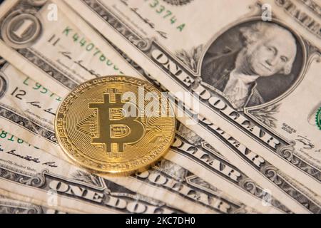 Illustration de pièce physique en or Bitcoin sur les billets en dollars américains. Représentations visuelles du Bitcoin crypto-monnaie numérique avec la facture en USD. Bitcoin avec le symbole BTC, XBT est une monnaie numérique populaire qui a montré la croissance et est largement répandue, acceptée par les banques, les marchés et d'autres services et magasins comme moyens de paiement. Le taux de change actuel pour la blockchain de 1 bitcoin est de 34,588 dollars américains. Sur 7 janvier 2021 le prix du Bitcoin a dépassé 40 000 pour la première fois et le lendemain sur 8 janvier 2021 le Bitcoin a échangé avec le prix record historique aussi élevé que $41 973 alors que le lendemain Banque D'Images