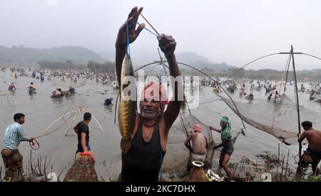 Un villageois indien montre ses prises lorsqu'il participe à la pêche communautaire dans le cadre des célébrations de Bhogali Bihu au lac Goroimari à Panbari, à environ 50 km de Guwahati, Inde le 13,2021 janvier. Bhogali Bihu est un festival de récolte célébré dans l'État d'Assam, dans le nord-est de l'Inde (photo d'Anuwar Hazarika/NurPhoto) Banque D'Images