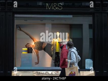 Un couple portant des masques de visage marche à côté d'un magasin Marks and Spencer sur Grafton Street à Dublin, vu pendant le confinement de niveau 5 Covid-19. Le vendredi 15 janvier 2021, à Dublin, Irlande. (Photo par Artur Widak/NurPhoto) Banque D'Images