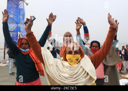 Un dévot hindou prie après avoir fait un plongeon Saint dans la baie du Bengale pendant la gégasaguar Mela, à l'île de Sagar, à environ 150 kilomètres au sud de Kolkata sur 14 janvier 2021. (Photo de Debajyoti Chakraborty/NurPhoto) Banque D'Images