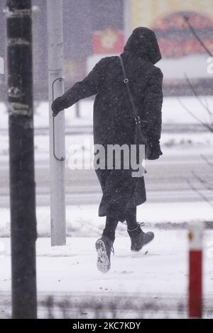 Une femme traverse une rue lors de fortes chutes de neige à Varsovie, en Pologne, sur 16 janvier 2021. Les vents froids de l'Arctique ont atteint la Pologne, ce qui a entraîné des baisses de près de 30 degrés en dessous de zéro et de fortes chutes de neige à travers le pays. Dans certains endroits, des rafales de vent allant jusqu'à 70 km/h sont attendues. (Photo de Jaap Arriens/NurPhoto) Banque D'Images