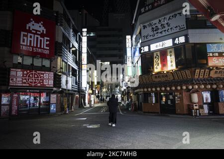 Un homme qui a fait le point pour un bar se tient rue déserte après 8 heures à Tokyo, Japon, le 11 janvier 2021. (Photo par Yusuke Harada/NurPhoto) Banque D'Images
