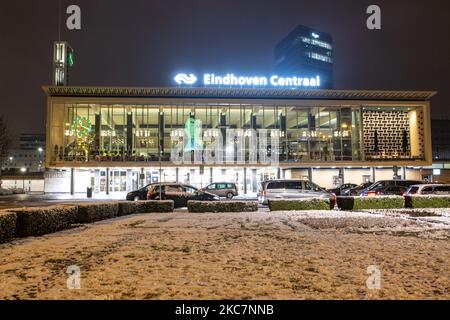 Eindhoven Centraal, la gare centrale de la ville avec l'inscription sur le dessus et la statue de Philips en face du bâtiment vu pendant la chute de neige. Photographie de nuit longue exposition des images enneigées et illuminées avec les lumières de la ville centre d'Eindhoven après la chute de neige. La vie quotidienne aux pays-Bas avec la première chute de neige de l'année couvrant presque tout le temps froid montre la température inférieure à zéro. L'état froid avec la neige et la glace a changé rapidement selon les prévisions, l'état de gel ne durera pas plus d'une journée. Eindhoven, pays-Bas Banque D'Images