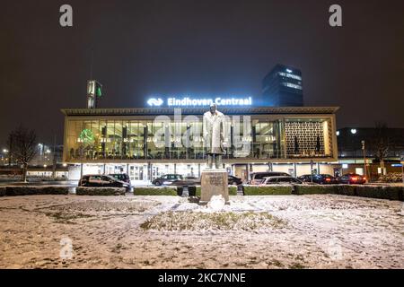 Eindhoven Centraal, la gare centrale de la ville avec l'inscription sur le dessus et la statue de Philips en face du bâtiment vu pendant la chute de neige. Photographie de nuit longue exposition des images enneigées et illuminées avec les lumières de la ville centre d'Eindhoven après la chute de neige. La vie quotidienne aux pays-Bas avec la première chute de neige de l'année couvrant presque tout le temps froid montre la température inférieure à zéro. L'état froid avec la neige et la glace a changé rapidement selon les prévisions, l'état de gel ne durera pas plus d'une journée. Eindhoven, pays-Bas Banque D'Images