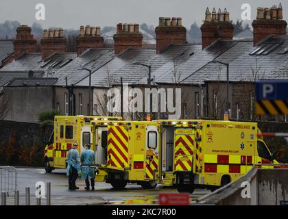 Deux ambulanciers paramédicaux vus près des ambulances garées à l'extérieur du département A et E de l'hôpital universitaire Mater Misericordiae de Dublin, pendant le troisième confinement national de l'Irlande. Le service de santé de l'Irlande est potentiellement confronté à la semaine la plus difficile de son histoire, le nombre de patients Covid-19 nécessitant un traitement intensif ayant fortement augmenté depuis la fin du mois de décembre. Le ministère de la Santé a signalé ce soir que 1 975 patients Covid-19 étaient hospitalisés pour le virus dans tout le pays, dont 200 en soins intensifs. Le lundi 18 janvier 2021, à Dublin, Irlande. (Photo Banque D'Images