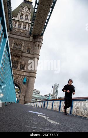 Un homme est vu courir un jour de pluie sur le pont vide de Tower Bridge tandis que le gouvernement britannique a introduit des restrictions strictes de coronavirus - politique de séjour à domicile de niveau 4 - plus tôt ce mois-ci en raison de l'augmentation du nombre de cas Covid-19 au Royaume-Uni - Londres, Angleterre sur 20 janvier 2021. Seuls les magasins essentiels peuvent être ouverts. L'exercice et la mise au travail sont des exceptions dans la politique rester à la maison. (Photo par Dominika Zarzycka/NurPhoto) Banque D'Images