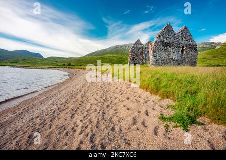 A côté d'une plage de sable, un manoir géorgien historique en ruines, sur les rives est du Loch Assynt, construit en 1726 pour Kenneth MacKenzie de la ville voisine de Ardvrek Castl Banque D'Images