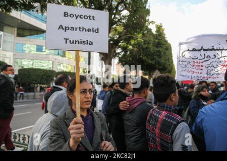 Une manifestante féminine porte un écriteau intitulé « boycotter la Tunisie de l'apartheid » lorsqu'elle a participé à une manifestation organisée dans la capitale Tunis, pour appeler à la chute du régime et pour protester contre la « violence policière » utilisée lors des dernières manifestations nocturnes qui ont éclaté dans le pays. Ils ont demandé la libération des jeunes manifestants arrêtés par la police. Des manifestants ont également protesté contre la déclaration du président du Conseil de Shura du parti islamiste tunisien Ennahdha, Abdelkarim Harouni, qui a déclaré : « les enfants d'Ennahdha seront sur le terrain pour soutenir la sécurité Banque D'Images