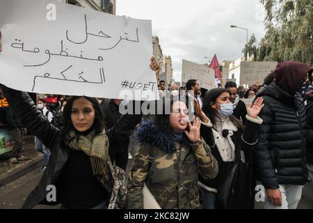 Une jeune protestante scanne des slogans anti-gouvernementaux alors qu’une autre élève un écriteau qui se lit en arabe : « le régime doit partir » lorsqu’elle a participé à une manifestation organisée dans la capitale Tunis, appeler à la chute du régime et à protester contre la « violence policière » utilisée lors des dernières manifestations nocturnes qui ont éclaté dans le pays. Ils ont demandé la libération des jeunes manifestants arrêtés par la police. Des manifestants ont également protesté contre la déclaration du président du Conseil de Shura du parti islamiste tunisien Ennahdha, Abdelkarim Harouni, qui a déclaré : « la femme Banque D'Images