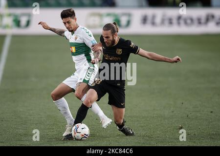 Emiliano Rigoni d'Elche et Oscar Mingueza de Barcelone concourent pour le ballon pendant le match de la Liga Santander entre Elche CF et FC Barcelone à l'Estadio Martinez Valero sur 24 janvier 2021 à Elche, Espagne. Les stades sportifs dans toute l'Espagne restent soumis à des restrictions strictes en raison de la pandémie du coronavirus, car les lois de distanciation sociale du gouvernement interdisent aux fans à l'intérieur des lieux, ce qui entraîne le jeu derrière des portes fermées. (Photo de Jose Breton/Pics action/NurPhoto) Banque D'Images