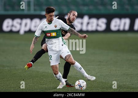 Emiliano Rigoni d'Elche et Oscar Mingueza de Barcelone concourent pour le ballon pendant le match de la Liga Santander entre Elche CF et FC Barcelone à l'Estadio Martinez Valero sur 24 janvier 2021 à Elche, Espagne. Les stades sportifs dans toute l'Espagne restent soumis à des restrictions strictes en raison de la pandémie du coronavirus, car les lois de distanciation sociale du gouvernement interdisent aux fans à l'intérieur des lieux, ce qui entraîne le jeu derrière des portes fermées. (Photo de Jose Breton/Pics action/NurPhoto) Banque D'Images