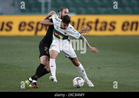 Emiliano Rigoni d'Elche et Oscar Mingueza de Barcelone concourent pour le ballon pendant le match de la Liga Santander entre Elche CF et FC Barcelone à l'Estadio Martinez Valero sur 24 janvier 2021 à Elche, Espagne. Les stades sportifs dans toute l'Espagne restent soumis à des restrictions strictes en raison de la pandémie du coronavirus, car les lois de distanciation sociale du gouvernement interdisent aux fans à l'intérieur des lieux, ce qui entraîne le jeu derrière des portes fermées. (Photo de Jose Breton/Pics action/NurPhoto) Banque D'Images