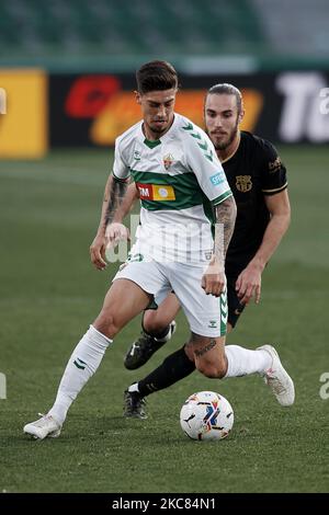 Emiliano Rigoni d'Elche et Oscar Mingueza de Barcelone concourent pour le ballon pendant le match de la Liga Santander entre Elche CF et FC Barcelone à l'Estadio Martinez Valero sur 24 janvier 2021 à Elche, Espagne. Les stades sportifs dans toute l'Espagne restent soumis à des restrictions strictes en raison de la pandémie du coronavirus, car les lois de distanciation sociale du gouvernement interdisent aux fans à l'intérieur des lieux, ce qui entraîne le jeu derrière des portes fermées. (Photo de Jose Breton/Pics action/NurPhoto) Banque D'Images