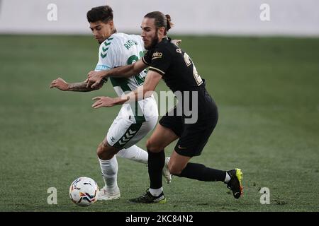 Emiliano Rigoni d'Elche et Oscar Mingueza de Barcelone concourent pour le ballon pendant le match de la Liga Santander entre Elche CF et FC Barcelone à l'Estadio Martinez Valero sur 24 janvier 2021 à Elche, Espagne. Les stades sportifs dans toute l'Espagne restent soumis à des restrictions strictes en raison de la pandémie du coronavirus, car les lois de distanciation sociale du gouvernement interdisent aux fans à l'intérieur des lieux, ce qui entraîne le jeu derrière des portes fermées. (Photo de Jose Breton/Pics action/NurPhoto) Banque D'Images