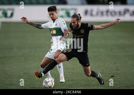Emiliano Rigoni d'Elche et Oscar Mingueza de Barcelone concourent pour le ballon pendant le match de la Liga Santander entre Elche CF et FC Barcelone à l'Estadio Martinez Valero sur 24 janvier 2021 à Elche, Espagne. Les stades sportifs dans toute l'Espagne restent soumis à des restrictions strictes en raison de la pandémie du coronavirus, car les lois de distanciation sociale du gouvernement interdisent aux fans à l'intérieur des lieux, ce qui entraîne le jeu derrière des portes fermées. (Photo de Jose Breton/Pics action/NurPhoto) Banque D'Images