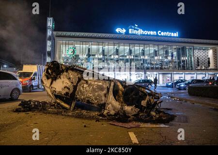 La voiture brûlée en face de la gare centrale d'Eindhoven. Les conséquences de la manifestation anti-verrouillage ont perturbé le centre-ville d'Eindhoven aux pays-Bas. Le deuxième jour du strict coronavirus Covid-19 mesures de verrouillage avec un couvre-feu imposé entre 21:00 et 04:30 par le gouvernement néerlandais depuis 23 janvier 2021, afin de lutter contre la propagation de la pandémie et la nouvelle mutation. Des centaines de manifestants se sont affrontés avec la police dans un rassemblement contre les nouvelles règles. La manifestation a entraîné des émeutes, des pillages et des dommages aux magasins, des fenêtres cassées et des dommages à la gare de settin Banque D'Images