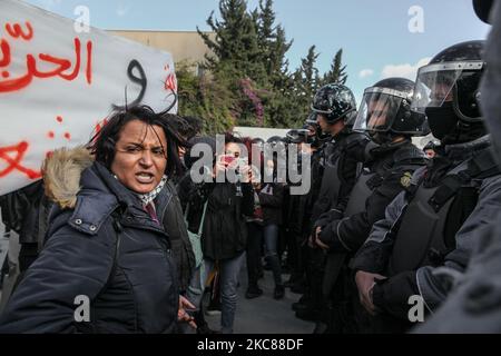 Une manifestante féminine fait face à des membres des forces de sécurité qui empêchent ses camarades de manifester devant le bâtiment de l'Assemblée des représentants du peuple (ARP) (Parlement tunisien) à Bardo. Des dizaines de jeunes du quartier difficile de Hay Ettadhamen, l'une des villes les plus peuplées de Tunis, sont descendus dans la rue dans une marche de protestation anti-gouvernementale qui a débuté de leur quartier et s'est dirigée vers la ville de Bardo à Tunis. Les manifestants ont particulièrement demandé la libération de jeunes arrêtés par la police lors des dernières manifestations nocturnes où ils se sont produits Banque D'Images