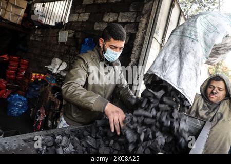 Un travailleur palestinien recueille le charbon de bois qui sera emballé dans des sacs pour le vendre à Jabaliya, dans le nord de la bande de Gaza, le 28 janvier 2021. (Photo de Majdi Fathi/NurPhoto) Banque D'Images