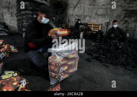 Un travailleur palestinien recueille le charbon de bois qui sera emballé dans des sacs pour le vendre à Jabaliya, dans le nord de la bande de Gaza, le 28 janvier 2021. (Photo de Majdi Fathi/NurPhoto) Banque D'Images