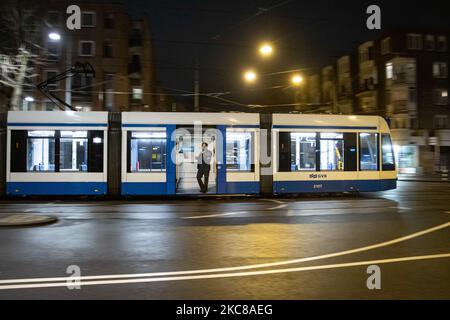 Un tramway vide après le couvre-feu à Amsterdam. Rues vides et calmes de la ville néerlandaise d'Amsterdam pendant le couvre-feu COVID. Les gens ne peuvent être dehors qu'avec une raison prouvée et une autorisation spéciale avec la documentation appropriée sinon ils sont condamnés à une amende de 95euro, à l'heure du couvre-feu de nuit. Les transports en commun comme le bus et le tram passent vides. Des policiers et des véhicules ont été déployés à Amsterdam pour donner un aperçu du couvre-feu. Les rues désertes du sont vues au quatrième jour avec le couvre-feu dans le pays, plus calmes après de violentes manifestations et des affrontements les jours précédents. Le couvre-feu a été imposé par le gouvernement Banque D'Images