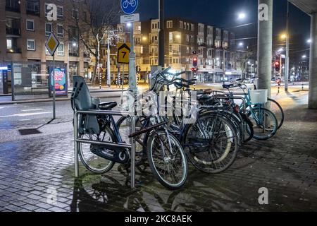 Vélos garés dans le quartier résidentiel pendant le couvre-feu. Rues vides et calmes de la ville néerlandaise d'Amsterdam pendant le couvre-feu COVID. Les gens ne peuvent être dehors qu'avec une raison prouvée et une autorisation spéciale avec la documentation appropriée sinon ils sont condamnés à une amende de 95euro, à l'heure du couvre-feu de nuit. Les transports en commun comme le bus et le tram passent vides. Des policiers et des véhicules ont été déployés à Amsterdam pour donner un aperçu du couvre-feu. Les rues désertes du sont vues au quatrième jour avec le couvre-feu dans le pays, plus calmes après de violentes manifestations et des affrontements les jours précédents. Le couvre-feu a été imposé par les gouvernorats Banque D'Images