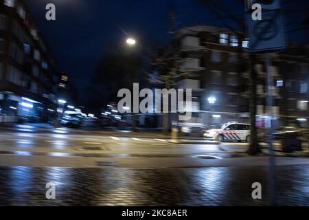 Voiture de police dans les rues. Rues vides et calmes de la ville néerlandaise d'Amsterdam pendant le couvre-feu COVID. Les gens ne peuvent être dehors qu'avec une raison prouvée et une autorisation spéciale avec la documentation appropriée sinon ils sont condamnés à une amende de 95euro, à l'heure du couvre-feu de nuit. Les transports en commun comme le bus et le tram passent vides. Des policiers et des véhicules ont été déployés à Amsterdam pour donner un aperçu du couvre-feu. Les rues désertes du sont vues au quatrième jour avec le couvre-feu dans le pays, plus calmes après de violentes manifestations et des affrontements les jours précédents. Le couvre-feu a été imposé par le gouvernement pour lutter contre la propagation Banque D'Images