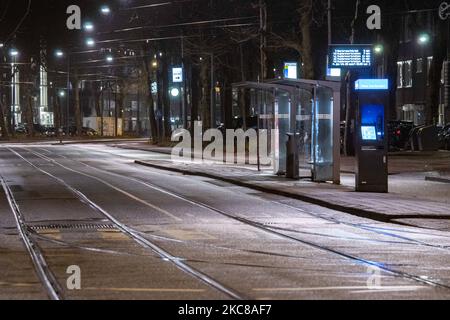 Arrêt de tramway. Rues vides et calmes de la ville néerlandaise d'Amsterdam pendant le couvre-feu COVID. Les gens ne peuvent être dehors qu'avec une raison prouvée et une autorisation spéciale avec la documentation appropriée sinon ils sont condamnés à une amende de 95euro, à l'heure du couvre-feu de nuit. Les transports en commun comme le bus et le tram passent vides. Des policiers et des véhicules ont été déployés à Amsterdam pour donner un aperçu du couvre-feu. Les rues désertes du sont vues au quatrième jour avec le couvre-feu dans le pays, plus calmes après de violentes manifestations et des affrontements les jours précédents. Le couvre-feu a été imposé par le gouvernement pour lutter contre la propagation du virus, followin Banque D'Images