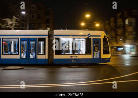 Un tramway vide après le couvre-feu à Amsterdam. Rues vides et calmes de la ville néerlandaise d'Amsterdam pendant le couvre-feu COVID. Les gens ne peuvent être dehors qu'avec une raison prouvée et une autorisation spéciale avec la documentation appropriée sinon ils sont condamnés à une amende de 95euro, à l'heure du couvre-feu de nuit. Les transports en commun comme le bus et le tram passent vides. Des policiers et des véhicules ont été déployés à Amsterdam pour donner un aperçu du couvre-feu. Les rues désertes du sont vues au quatrième jour avec le couvre-feu dans le pays, plus calmes après de violentes manifestations et des affrontements les jours précédents. Le couvre-feu a été imposé par le gouvernement Banque D'Images