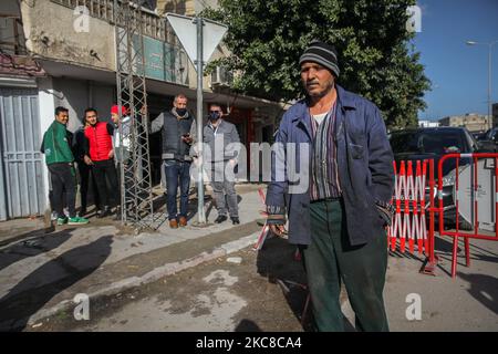 Les habitants d'un quartier difficile sont vus dans la rue de la ville populaire d'Ettadhamen, qui est l'une des villes les plus peuplées de la capitale Tunis. La ville d'Ettadhamen, dont le nom signifie « solidarité », a été formée par les vagues de migrations internes (pauvres, petits agriculteurs et chômeurs) qui ont marqué la Tunisie au début de l'année 1950s. La jeunesse du quartier a joué un rôle central dans la révolution de 2011 qui a renversé le président Zine el-Abidine Ben Ali. Depuis, la situation s'est aggravée : précarité, pauvreté, augmentation du coût de la vie, chômage, abandon scolaire, consommation de drogues, désespoir, marge Banque D'Images