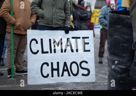 Un manifestant affiche un panneau indiquant « chaos climatique » lors d'une manifestation sur un pipeline de la ligne 3 dans le centre-ville de St. Paul, Minnesota. 29 janvier 2021. Près de 600 activistes et protecteurs d'eau ont pris part vendredi soir à St. Paul, Minnesota, à une manifestation contre le pipeline de la ligne 3 d'Enbridge. L'événement a été organisé par plus d'une douzaine de groupes, dont Sunrise Movement MN, Honor the Earth, International Indigenous Youth Council, Environment MN, MN350, et d'autres. Les participants ont demandé au gouverneur Tim Walz ainsi qu'à la Société des ingénieurs de l'Armée de terre de révoquer le permis du pipeline sur la sécurité environnementale et le gro humanitaire Banque D'Images