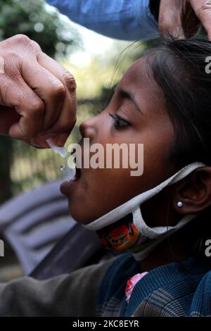 Un enfant est administré à un enfant des gouttes de vaccin contre la polio par des agents de santé dans une société d'habitation à 31 janvier 2021 à New Delhi. L'Inde observe aujourd'hui la Journée nationale de vaccination contre la polio, où des gouttes sont administrées aux enfants de moins de 5 ans pour garder la maladie à distance. Le ministère de la Santé a déclaré que la vaccination antipoliomyélitique à impulsion sera reprise sur 31 janvier, 1 février et 2. (Photo de Mayank Makhija/NurPhoto) Banque D'Images