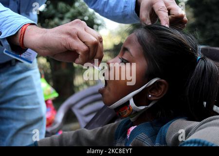 Un enfant est administré à un enfant des gouttes de vaccin contre la polio par des agents de santé dans une société d'habitation à 31 janvier 2021 à New Delhi. L'Inde observe aujourd'hui la Journée nationale de vaccination contre la polio, où des gouttes sont administrées aux enfants de moins de 5 ans pour garder la maladie à distance. Le ministère de la Santé a déclaré que la vaccination antipoliomyélitique à impulsion sera reprise sur 31 janvier, 1 février et 2. (Photo de Mayank Makhija/NurPhoto) Banque D'Images