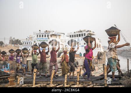 Les travailleurs de jour déchargent le charbon d'un cargo à Gabtoli, Dhaka, sur 3 février 2021. Les travailleurs gagnent en moyenne environ 1 USD par jour pour leur travail acharné. (Photo d'Ahmed Salahuddin/NurPhoto) Banque D'Images